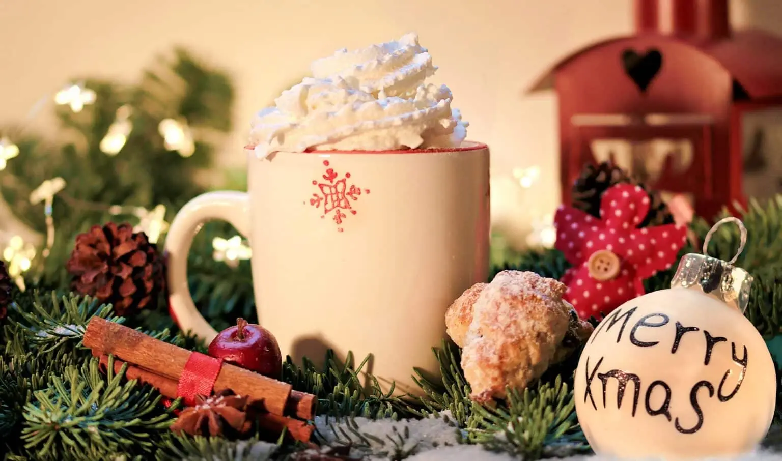 Festliche weihnachtliche Tasse mit Schlagsahne, Dekoration und Weihnachtsgirlande.